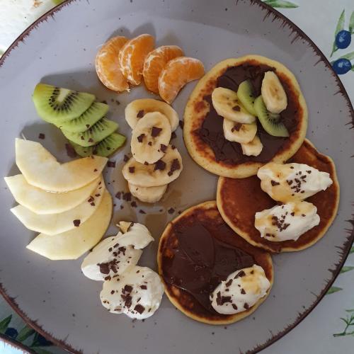 Pancakes mit Mandarinen, Äpfeln, Kiwis, Bananen und Schokosauce
