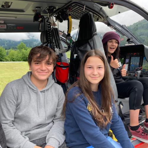 Drei Schülerinnen sitzen in einem Helikopter.