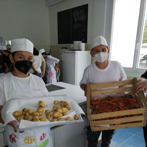 Zwei Kinder der 3b halten Körbe mit Kartoffeln und Karotten