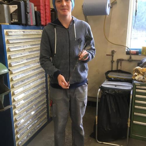 Schüler mit einer Metallrose in der Hand