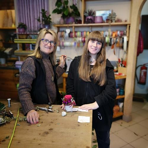 Schülerin an der Kassa eines Blumengeschäfts