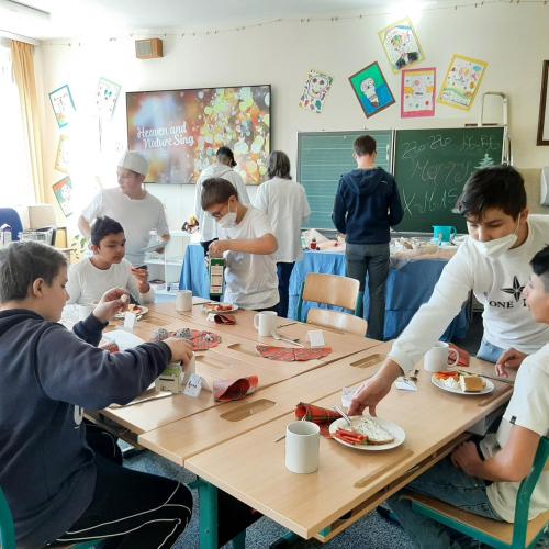 Schüler:innen beim Servieren und Essen der gesunden Jause.