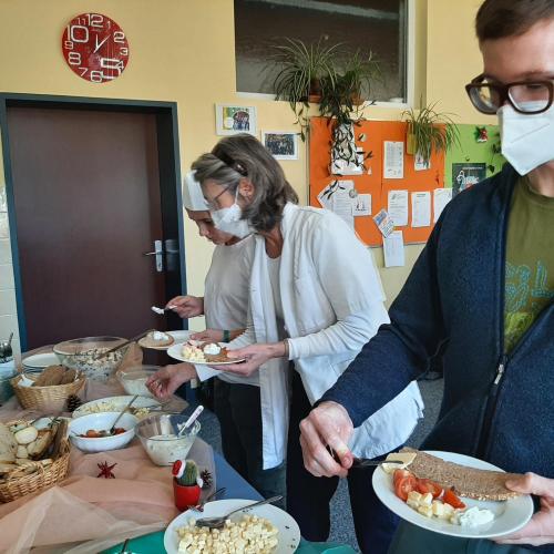 Lehrpersonen, die sich Essen vom Buffet holen.