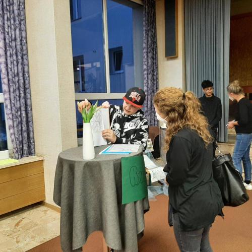 Eine Lehrperson hört sich den Vortrag eines Schülers an.