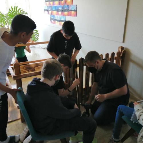 Schüler:innen und Lehrperson beim Errichten des Geheges.