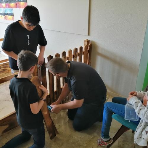 Schüler:innen und Lehrperson beim Errichten des Geheges.
