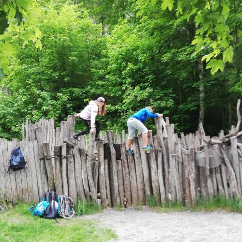 Schüler:innen klettern über einen Zaun.