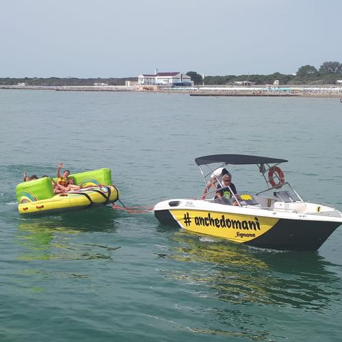 SchülerInnen bei einer sportlichen Aktivität. Sitzen in einem Gummireifen und werden von einem Motorboot nachgezogen.