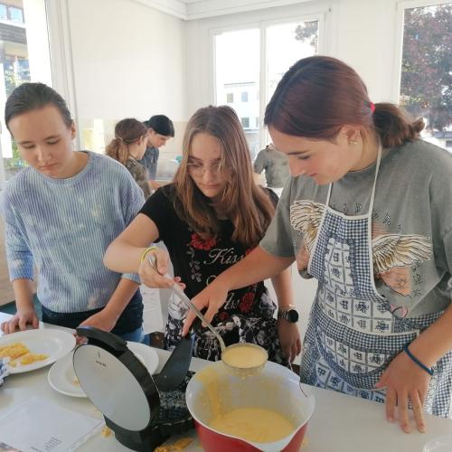Schülerinnen beim backen von Waffeln.