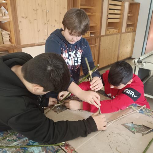 Drei Schüler bauen ein Haus. Teamwork ist alles.