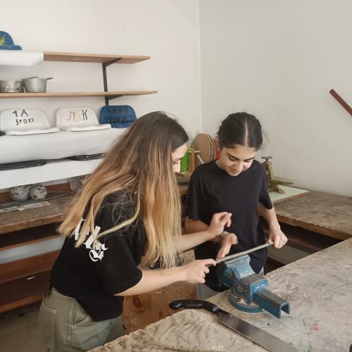 Zwei Schülerinnen bearbeiten ein Holzstück.