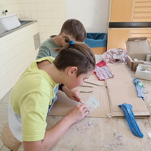 Schüler:innen stellen Schmuck aus Speckstein her. 