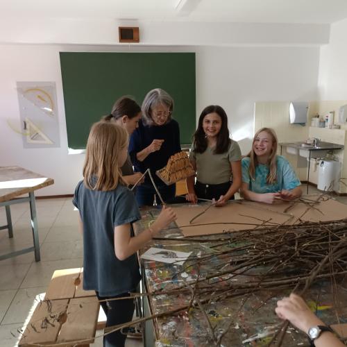Schüler:innen besprechen mit der Lehrperson die Vorgehensweise.