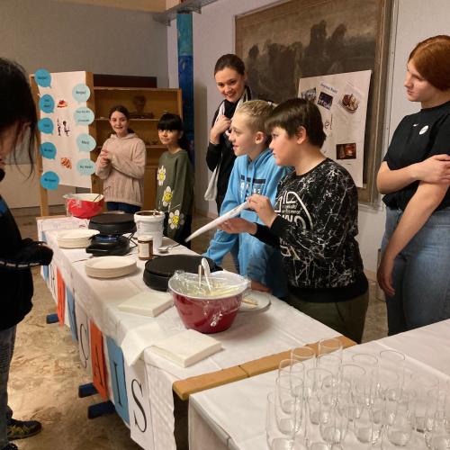 Schüler:innen beim Ausgeben von Crepes beim Französischstand.