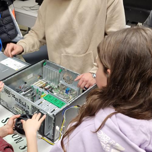 Ein Schüler der MS Königsweg zeigt einer Volksschülerin einen auseinandergebauten PC.