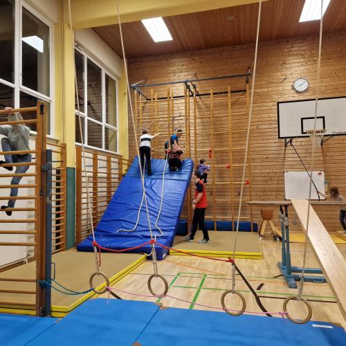 Schüler:innen versuchen sich am Parcours im Turnsaal. 