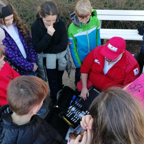 Schüler:innen werden die Inhalte eines Rettungsautos gezeigt. 