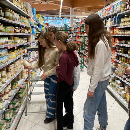 Schülerinnen beim Einräumen von verschiedenen Produkten.