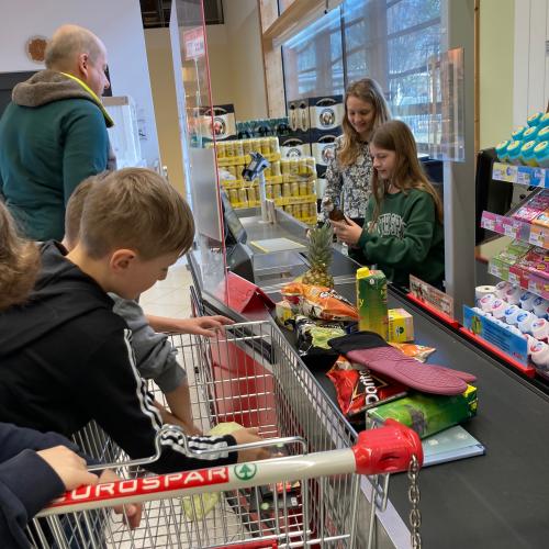 Schülerin beim Kassieren von Waren. 