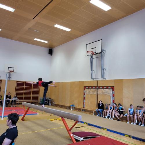 Turnerin macht eine Standwaage auf dem Schwebebalken