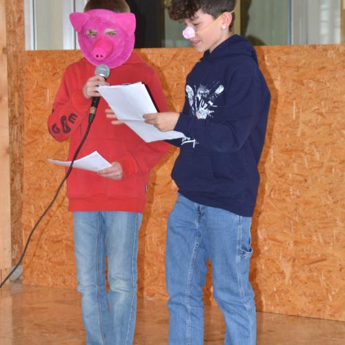 Zwei Schüler sind als Schweinchen verkleidet und präsentieren einen Dialog. 