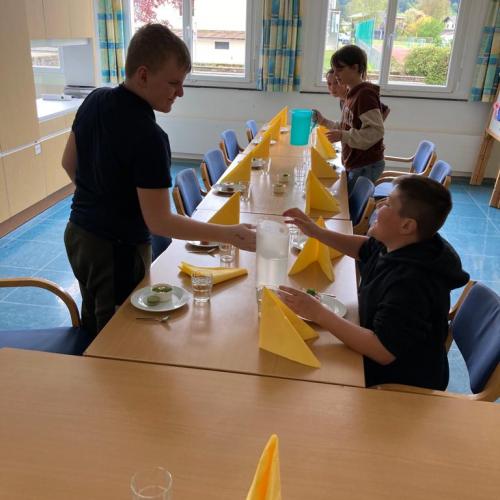 Schüler decken den Tisch. 