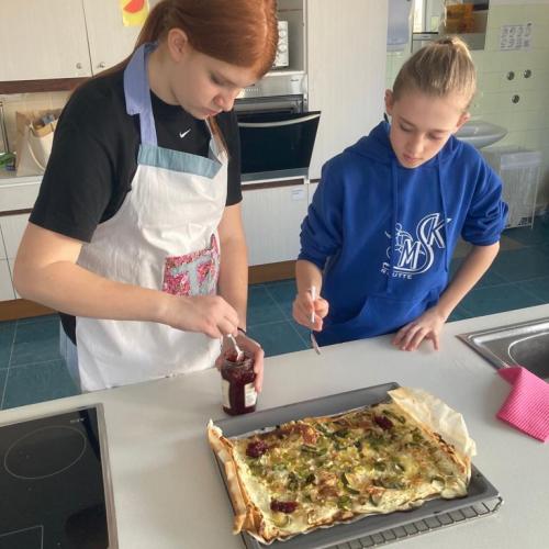 Schülerin und Schüler bereiten die französische Hauptspeise vor.