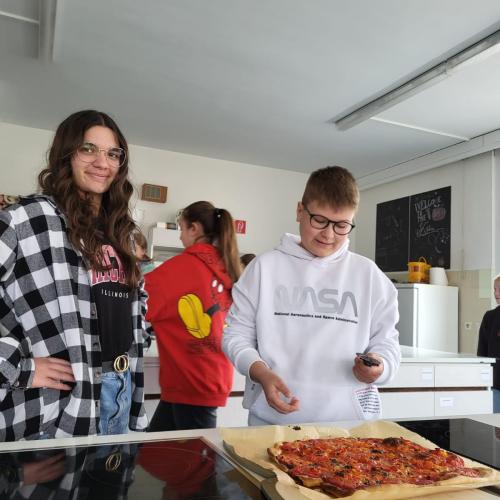 Schüler beim Aufschneiden der Pizza.