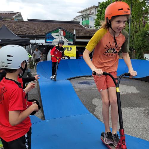 Schüler und Schülerin fahren mit dem Scooter im Pumptrack.