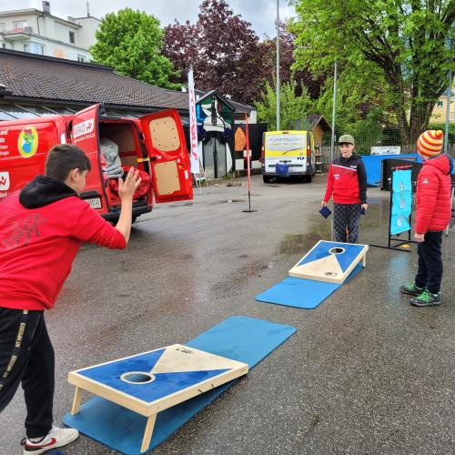Drei Schüler beim Cornhole spielen.