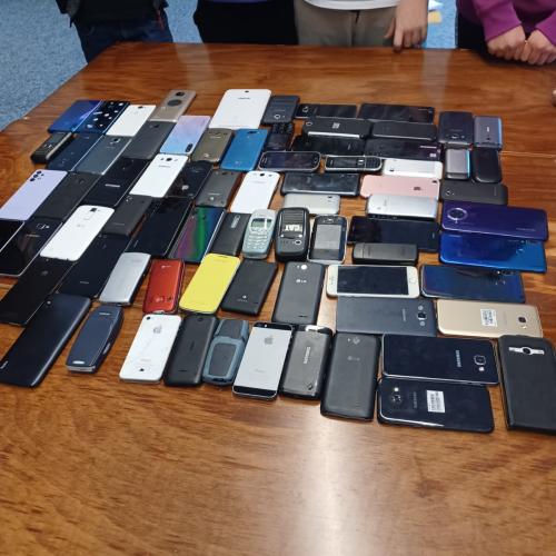 Die gesammelten Smartphones liegen auf einem Tisch.  