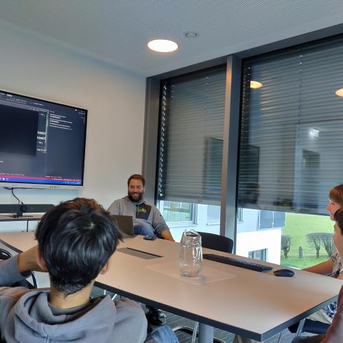 Drei Schüler im Besprechungsraum mit ihrem Vorgesetzten. 