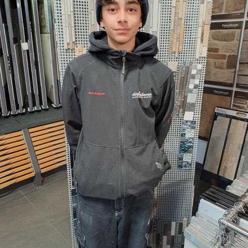 Ein Schüler steht vor verschiedenen Fliesen. 