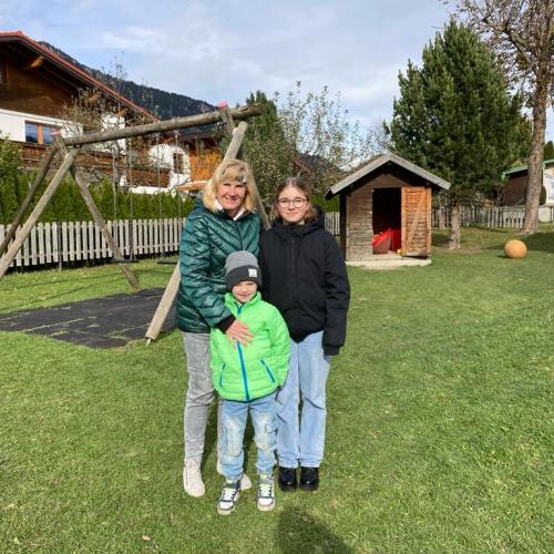 Foto einer Schülerin, einem Kindergartenkind und der Kindergartenpädagogin im Garten des Kindergartens Höfen.
