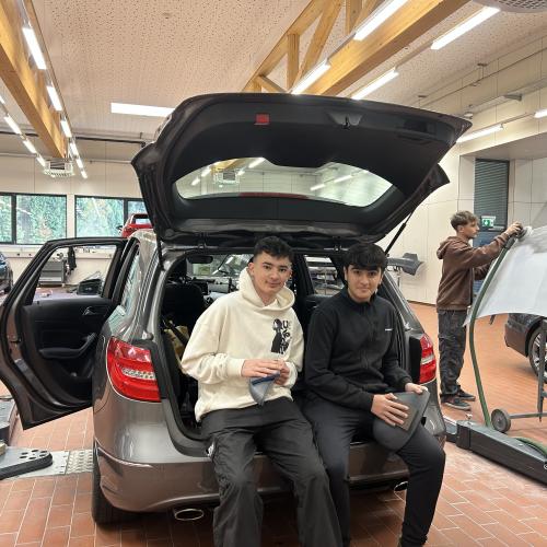 Zwei Schüler beim Autohaus Schweiger. 