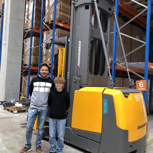 Ein Schüler steht mit seinem Vorgesetzen vor einem Stapler.