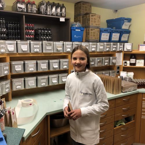 Eine Schülerin schnuppern in der Apotheke. 