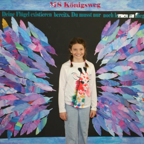 Schülerin vor der Fotowand des WPF Kreativ. 