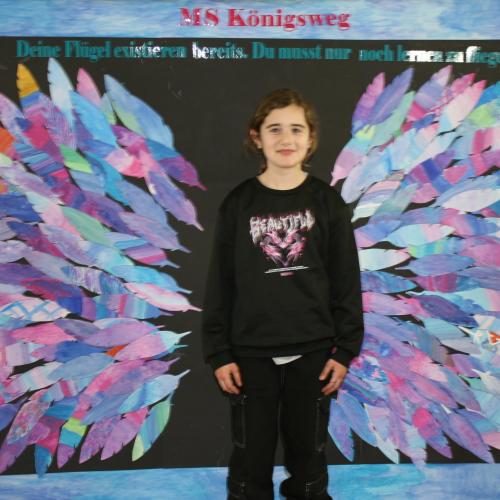 Schülerin vor der Fotowand des WPF Kreativ. 