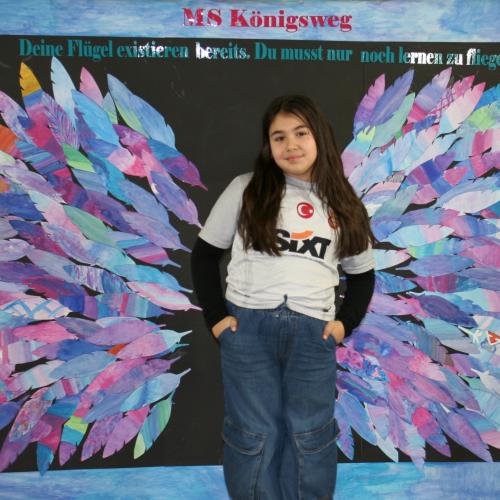 Schülerin vor der Fotowand des WPF Kreativ. 