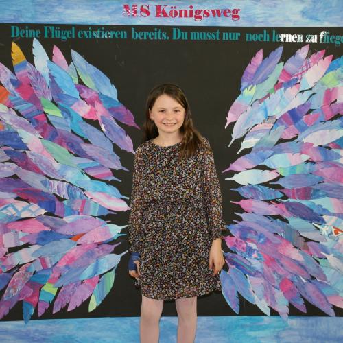 Schülerin vor der Fotowand des WPF Kreativ. 