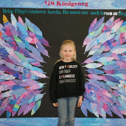 Schülerin vor der Fotowand des WPF Kreativ. 