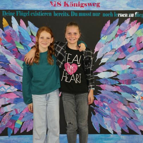 Schülerinnen vor der Fotowand des WPF Kreativ. 