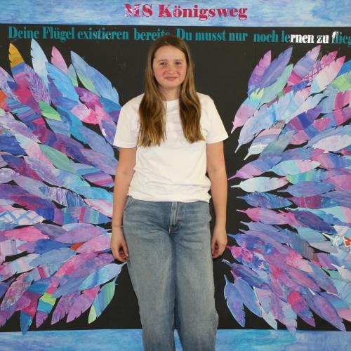 Schülerin vor der Fotowand des WPF Kreativ. 