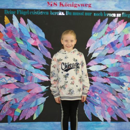 Schülerin vor der Fotowand des WPF Kreativ. 