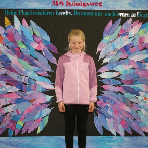 Schülerin vor der Fotowand des WPF Kreativ. 