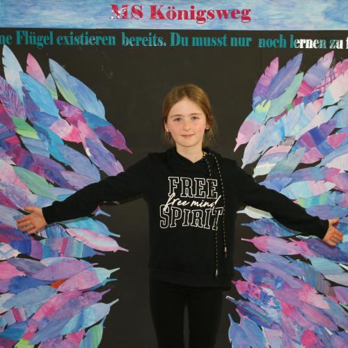 Schülerin vor der Fotowand des WPF Kreativ. 