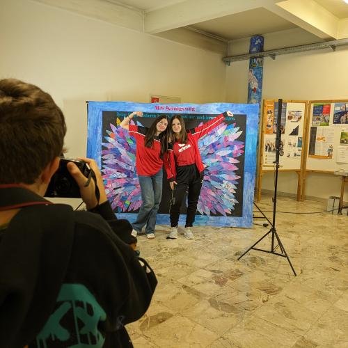Schüler posieren vor der Fotowand. 