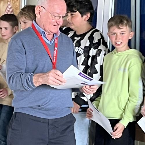 Eine Lehrperson teilt die Zertifikate aus.