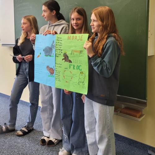 eine Gruppe Schüler präsentiert ihr Plakat.